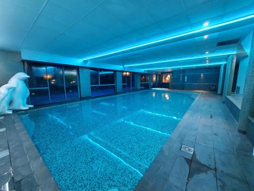 a swimming pool in a building with blue lighting at Best Western Aquakub in Aix-les-Bains