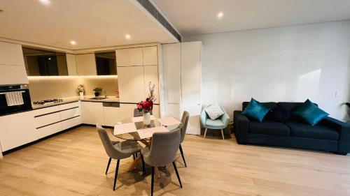 a kitchen and a living room with a table and chairs at ChinatownICCHaymarket Adorable 2Br Apt at CBD in Sydney