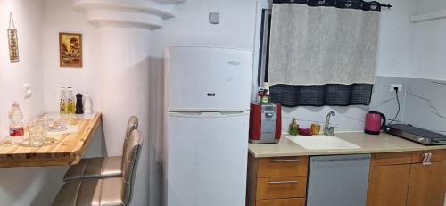 a small kitchen with a refrigerator and a sink at RutSuite in El ‘Affūle