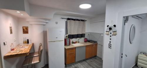 a kitchen with a white refrigerator and a sink at RutSuite in Afula