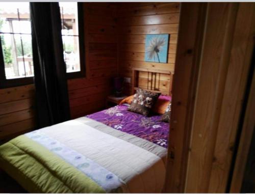 a bedroom with a bed in a wooden cabin at Cabañas Caudiel in Caudiel