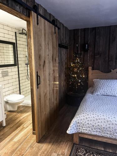 a bedroom with a bed and a bathroom with a christmas tree at Apartamenty Góralski DACH NAD GŁOWĄ in Poronin