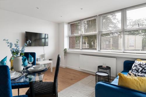 - un salon avec une table et un canapé bleu dans l'établissement Livestay-Modern Apartments Building in Aylesbury, à Buckinghamshire