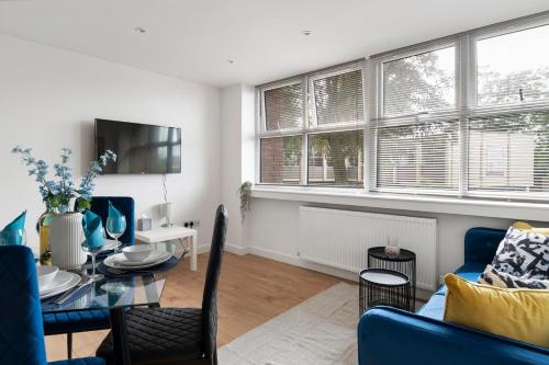 a living room with a table and a blue couch at Livestay-Modern Apartments Building in Aylesbury in Buckinghamshire