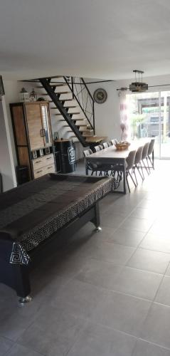 un salon avec une table et des chaises et un escalier dans l'établissement circuit 24H le Mans, à Marigné-Laillé