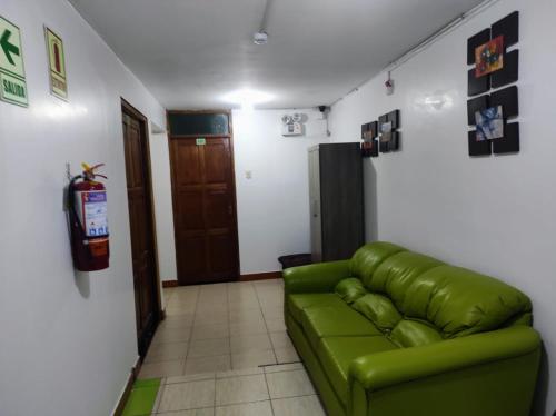 een woonkamer met een groene bank in een kamer bij Sierra Verde - Muy Céntrico Hs in Huancayo