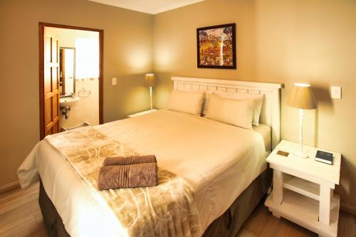 a bedroom with a large white bed with a night stand at Dalene se Seehuis, Langebaan, 8-sleeper in Langebaan
