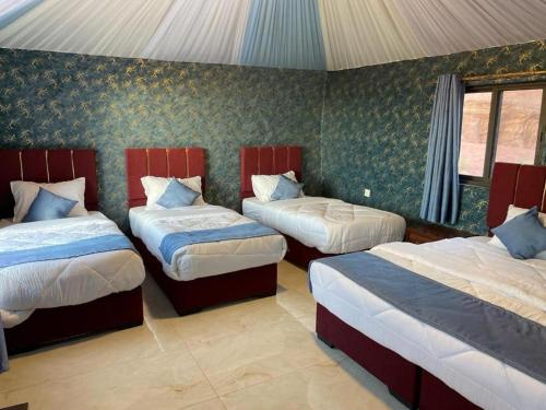 a bedroom with three beds in a room at Star Walk Camp & Tours in Wadi Rum