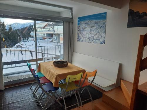 een tafel en stoelen in een kamer met een raam bij ABITARE MARILLEVA in Trento