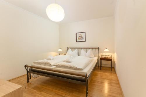 シュラートミンクにあるAppartement Alpenresort by Schladming-Appartementsのベッドルーム1室(白いシーツと白い枕のベッド1台付)