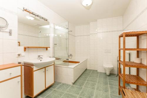 a bathroom with a sink and a tub and a toilet at Appartement Alpenresort by Schladming-Appartements in Schladming