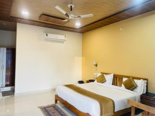 a bedroom with a bed and a ceiling fan at The Deerfield Cottages in Rāmnagar