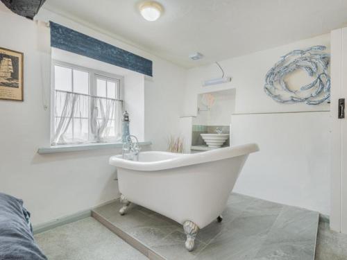 a white bath tub in a bathroom with a window at 3 Bed in Baycliff SZ130 in Baycliff