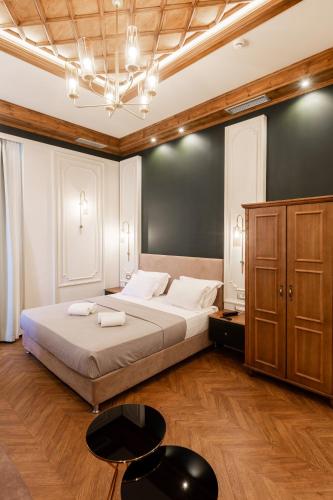 a bedroom with a large bed and a black wall at King Othon Boutique Hotel in Nafplio