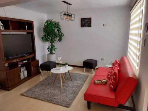 a living room with a red couch and a table at Dpto interior nuevo, excelente ubicacion in Coquimbo