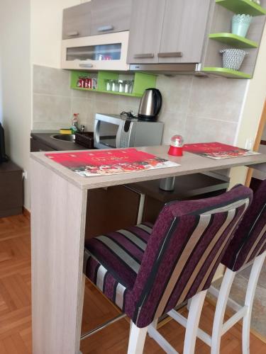 a kitchen with a table and two bar stools at Zlatiborski konaci k14/3 in Zlatibor