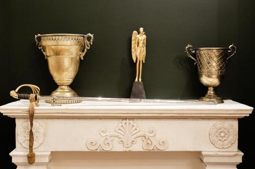 two vases on a white table with a green wall at King Othon Boutique Hotel in Nafplio