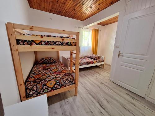 2 łóżka piętrowe w pokoju z drzwiami w obiekcie PEACE & LODGE II w mieście Saint-Joseph
