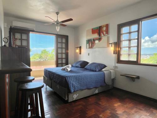 um quarto com uma cama e uma grande janela em Pousada Canajurê em Florianópolis
