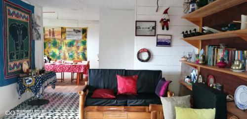 a living room with a black couch and a table at Roça do Lucindo in Santo António
