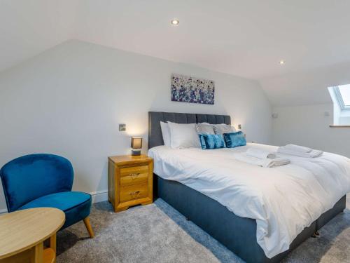 a bedroom with a bed and a blue chair at 5 Bed in Barnstaple 85165 in Charles