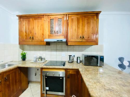 a kitchen with wooden cabinets and a sink at The crib in Roodepoort