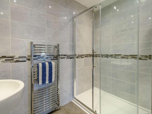a bathroom with a glass shower and a sink at 2 Bed in Tenby 87912 in Tenby