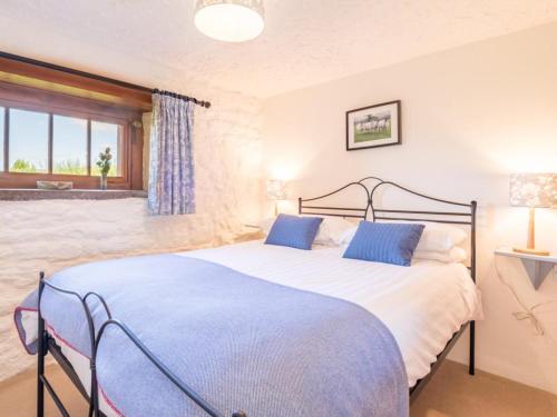 a bedroom with a large bed with blue pillows at 2 Bed in Eden Valley SZ209 in Kirkoswald