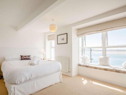 a white bedroom with two beds and a window at 4 Bed in Aberdovey 87520 in Aberdyfi