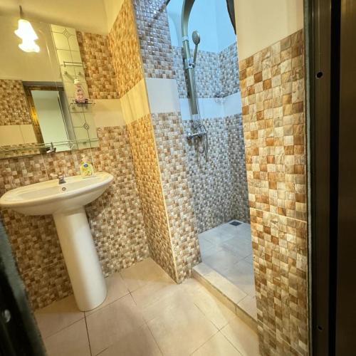 a bathroom with a sink and a shower at BAMBOO LODGE - la Criquet 'Event' in Lomé
