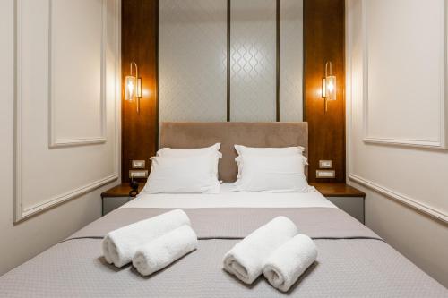 a bedroom with a bed with two towels on it at King Othon Boutique Hotel in Nafplio
