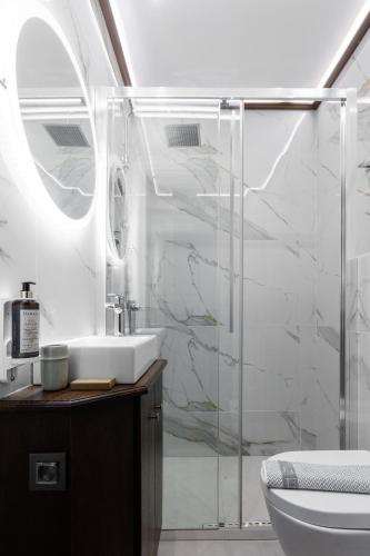 a bathroom with a sink and a glass shower at King Othon Boutique Hotel in Nafplio