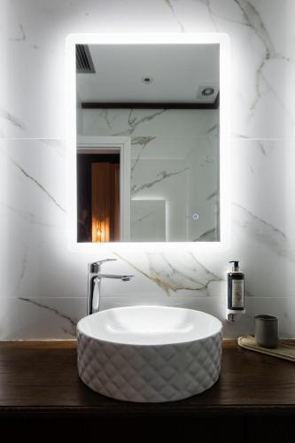 a bathroom with a large white sink and a mirror at King Othon Boutique Hotel in Nafplio