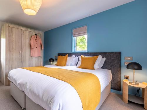 a bedroom with a large bed with blue walls at 2 Bed in St. Mellion 87715 in St Mellion