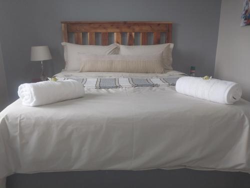 1 cama blanca grande con 2 almohadas en Modern two bedroom apartment., en Port Alfred