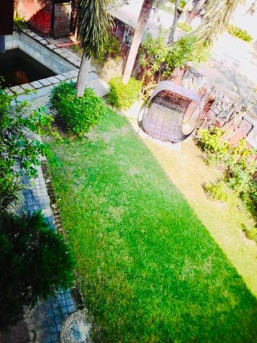 a green lawn with a table and some chairs at Raichak Ak22 Homestay in Raichak