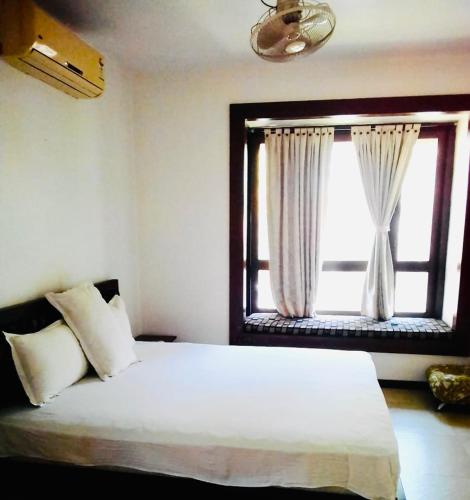 a bedroom with a large white bed with a window at Raichak Ak22 Homestay in Raichak