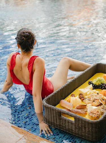 a woman sitting in the water with a basket of food at Hyatt Pune in Pune