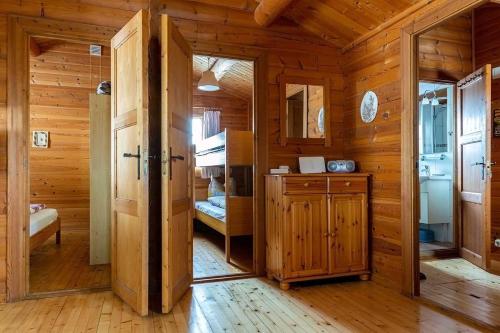 a wooden cabin with a kitchen and a bedroom at Blockhaus am Diemelsee in Sudeck