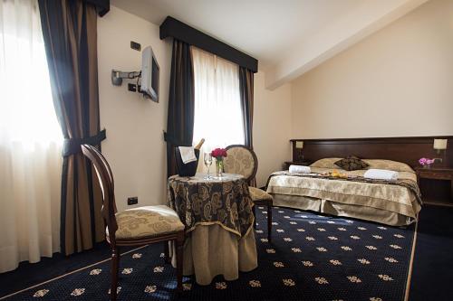 a hotel room with a bed and a table and chairs at Antica Stazione in Chiaramonte Gulfi