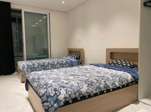 a bedroom with two beds with blue and white sheets at y park in Seoul