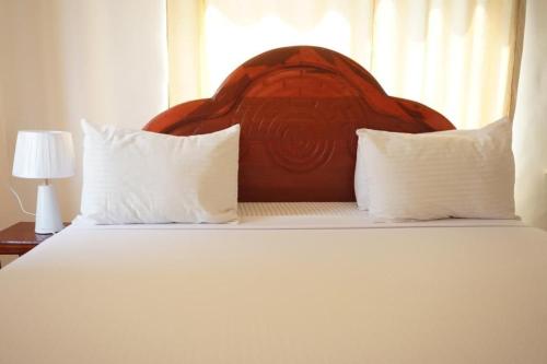 1 dormitorio con 1 cama grande y 2 almohadas en Asili Nyumbani Residence, en Kiwengwa