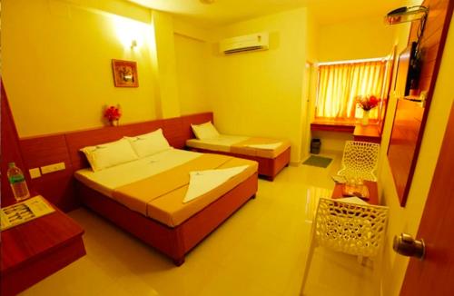 a bedroom with a bed and a couch and a table at Skylink residency in Chennai