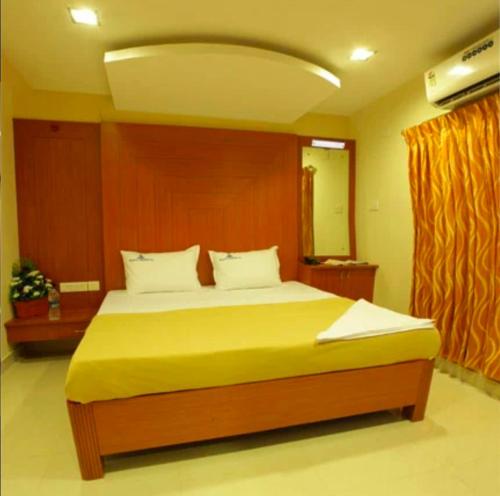 een slaapkamer met een groot bed met een houten hoofdeinde bij Skylink residency in Chennai