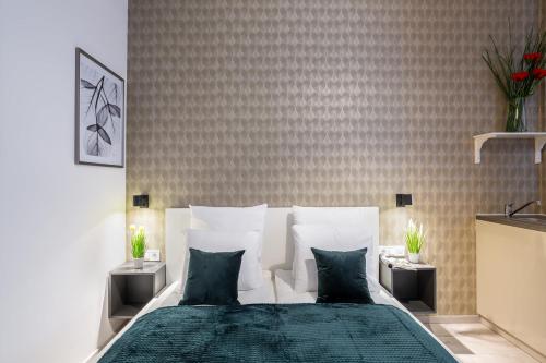 a bedroom with a bed with green sheets and pillows at Extra Central New & Stylish Studio in Budapest