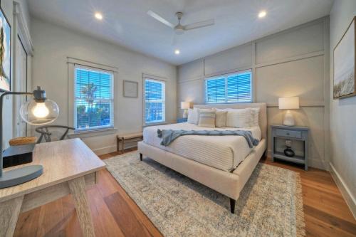 1 dormitorio con cama, mesa y ventanas en Always Sunny by AvantStay Golf Cart Zone, en Port Aransas
