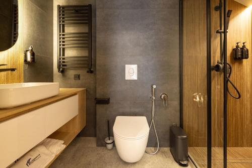 a bathroom with a toilet and a sink at Black & White Villas by Fomich Hotels Group in Bukovel