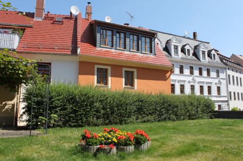 dom z kwiatami na podwórku w obiekcie Ferienhaus "Im Wall" w mieście Görlitz
