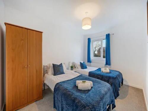 two beds in a room with blue and white at Pass the Keys 3 bedroom modern house in Withington in Manchester