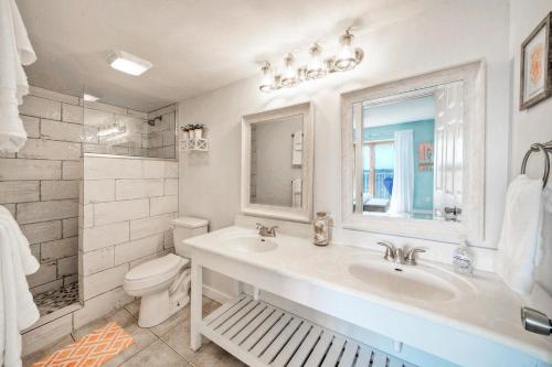 Baño blanco con lavabo y aseo en Rise N Beach by AvantStay Golf Cart Zone en Port Aransas